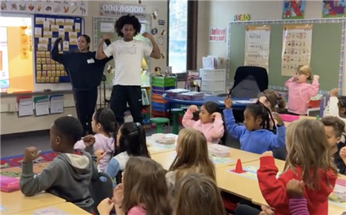 students working with students raising arms